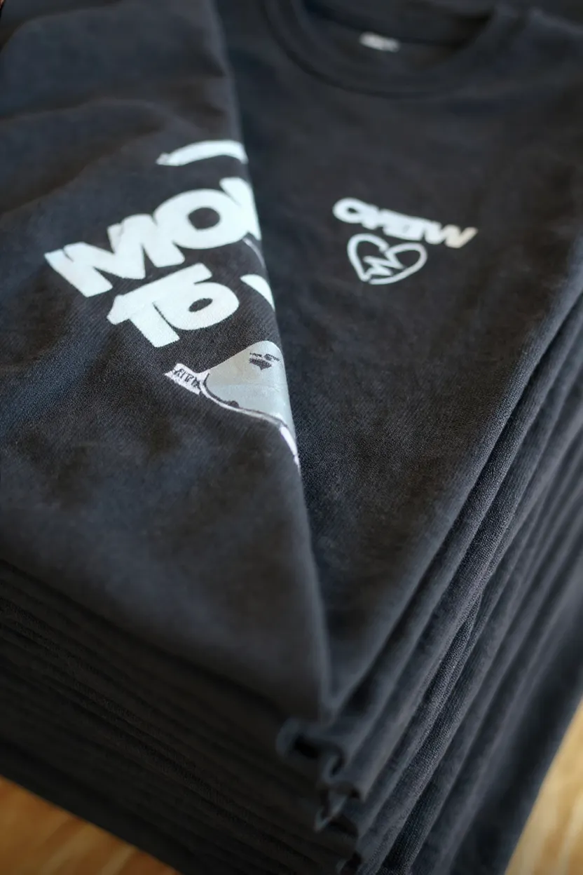 Frisch bedruckte T-Shirts, ordentlich gestapelt in der Werkstatt